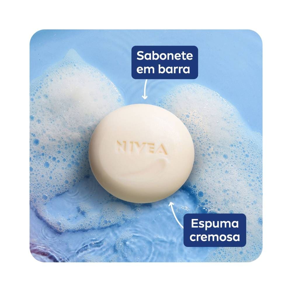 Sabonete em barra Nivea Creme Care em um fundo azul com bolhas de sabão, mostrando espuma cremosa.